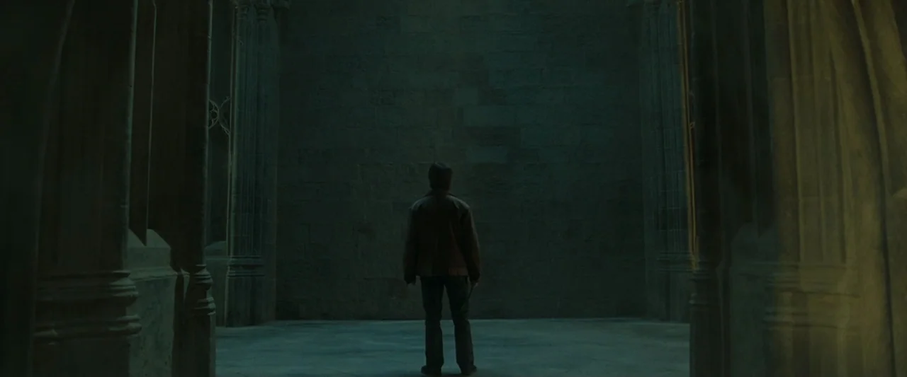 Harry Potter & The Deathly Hallows Part 2 (2011) movie still: fullbody — A dark, empty hall constructed from massive stone blocks and tall arched…