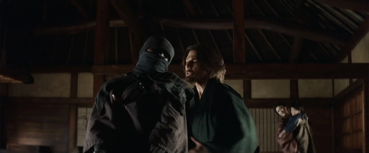 The Last Samurai (2003) movie still: medium — A dimly lit room with wooden beams and traditional Japanese architectural elements in the background.…