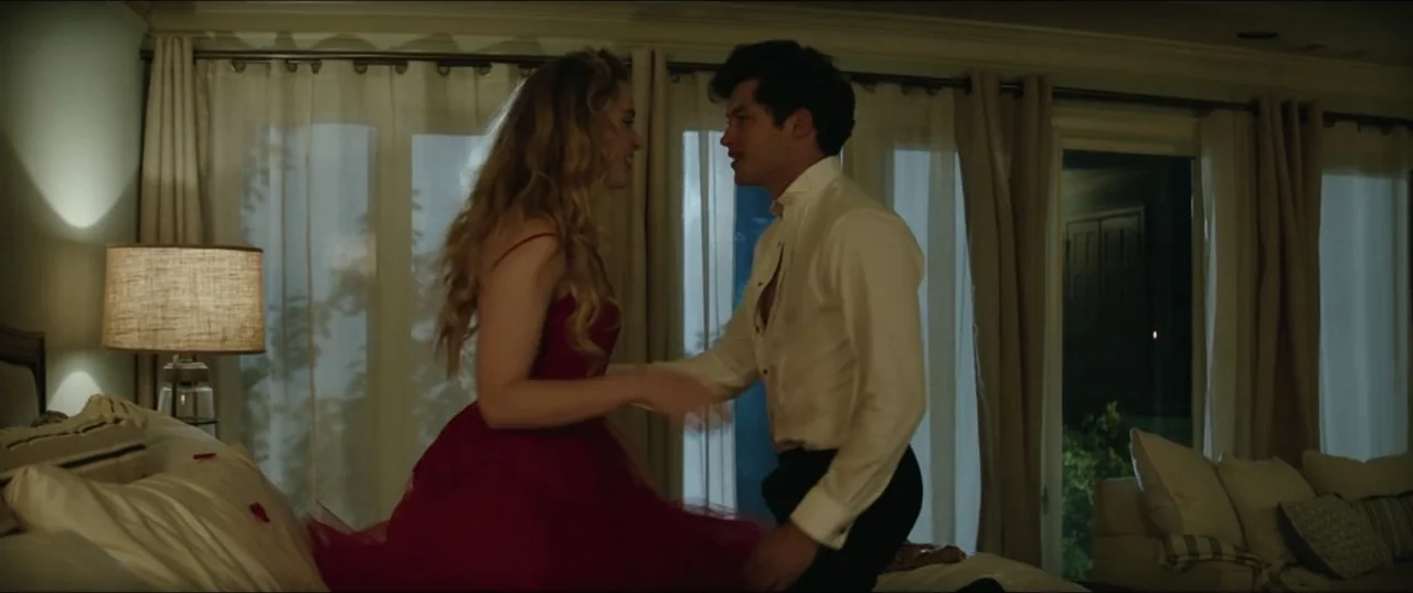 Blockers (2018) movie still: medium — A well-lit bedroom features a large bed positioned in front of sheer white curtains. A young couple in formal…