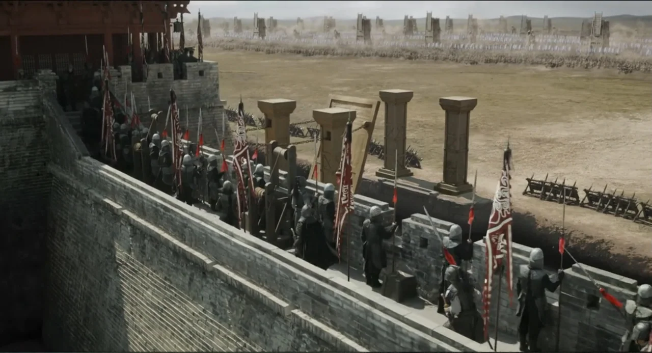 Legends of the Condor Heroes: The Gallants (2025) movie still: wide — A long stone fortress wall features battlements lined with soldiers carrying…