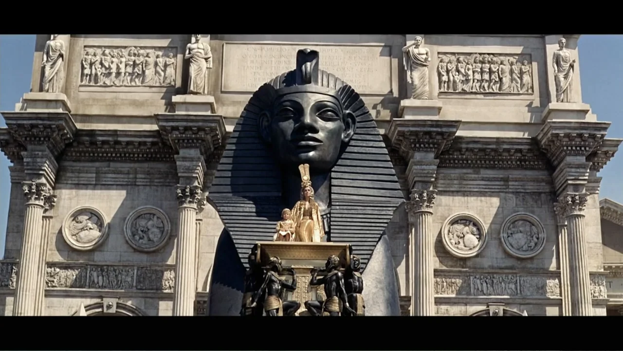 Elizabeth Taylor: The Lost Tapes (2024) movie still: wide — A massive stone facade features a giant black pharaonic statue above a golden throne. A…