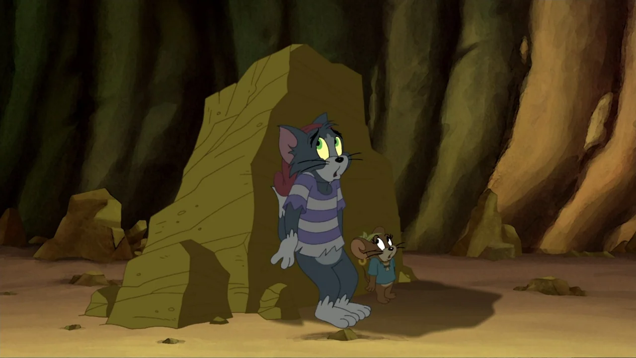 Tom and Jerry: Shiver Me Whiskers (2006) movie still: fullbody — A rocky, cavernous interior with tall stone walls and a sandy floor. An…