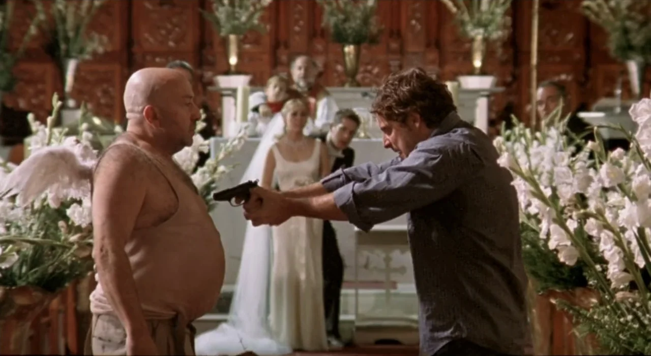 Sex, Love And Other Perversions II (2006) movie still: medium — An ornate interior with dark wood paneling and banks of white flowers. One man…
