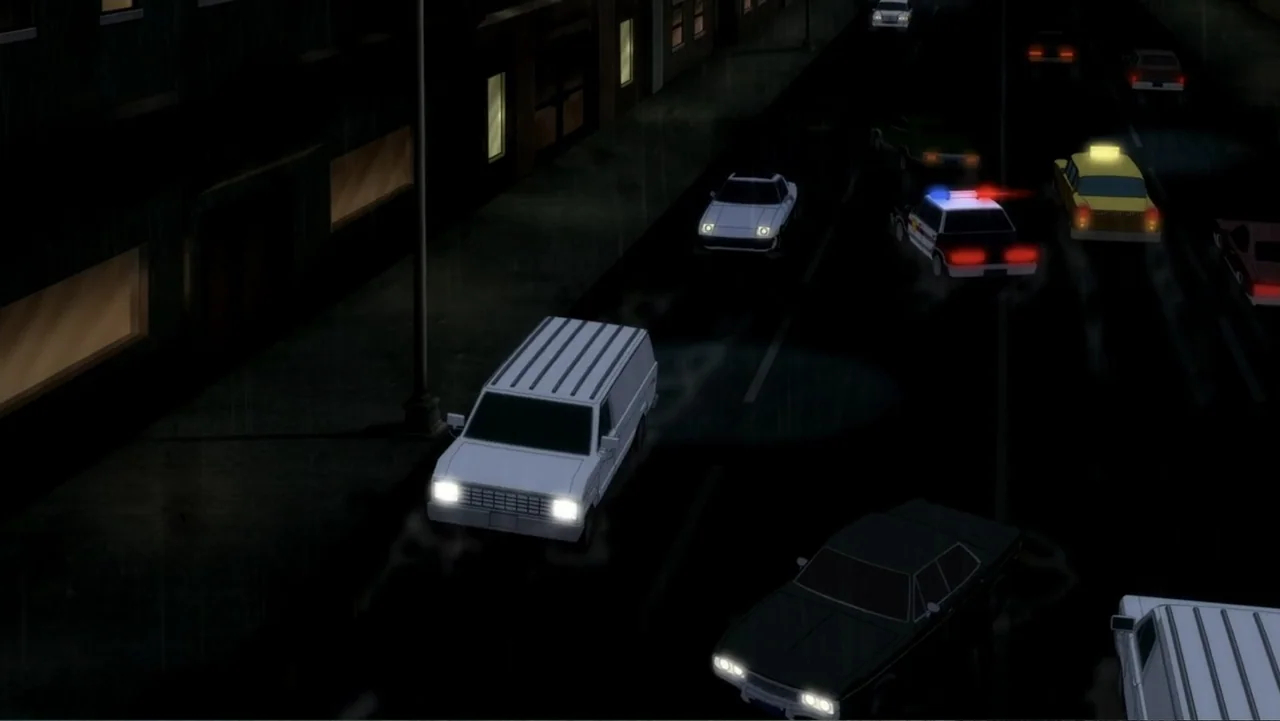 Batman: The Dark Knight Returns, Part 1 (2012) movie still: wide — An urban road at night during a rainstorm with several vehicles driving past…