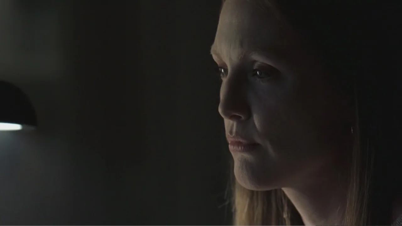 Hannibal (2001) movie still: closeup — An interior space is cast in darkness with a single practical lamp source. A woman is seen in profile view,…