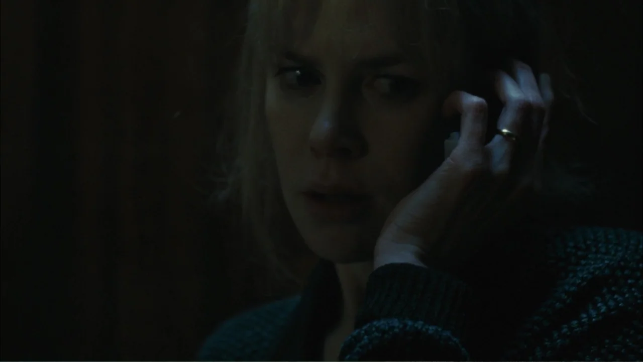 Before I Go to Sleep (2014) movie still: closeup — A dark indoor space where a woman remains in deep shadow. She holds a phone against her ear while…
