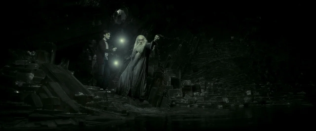 Harry Potter & The Half Blood Prince (2009) movie still: wide — A dark subterranean cave filled with sharp obsidian-like rocks and black water. An…