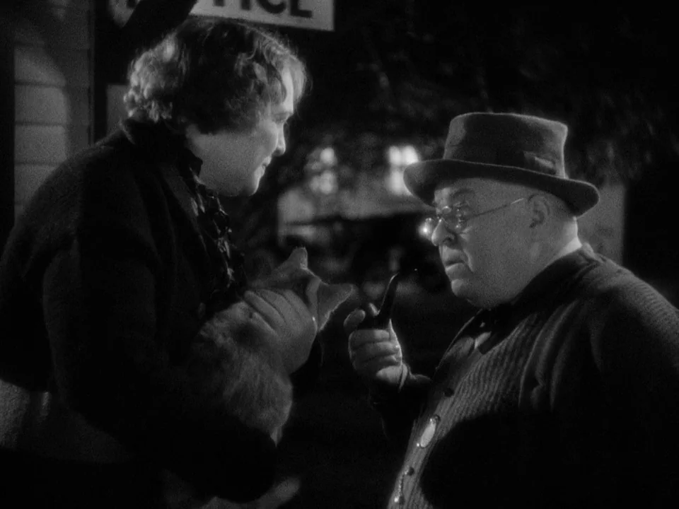 It Happened One Night (1934) movie still: medium — A night scene shows an elderly man with a pipe facing a woman holding a dog. The man wears a hat…