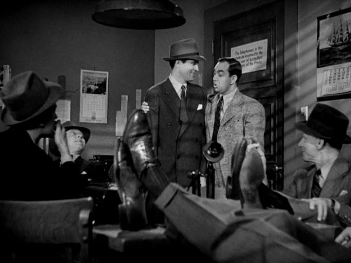 Stranger on the Third Floor (1940) movie still: medium — A 1940s press room features cluttered desks, wall calendars, and a door sign. Men in suits…