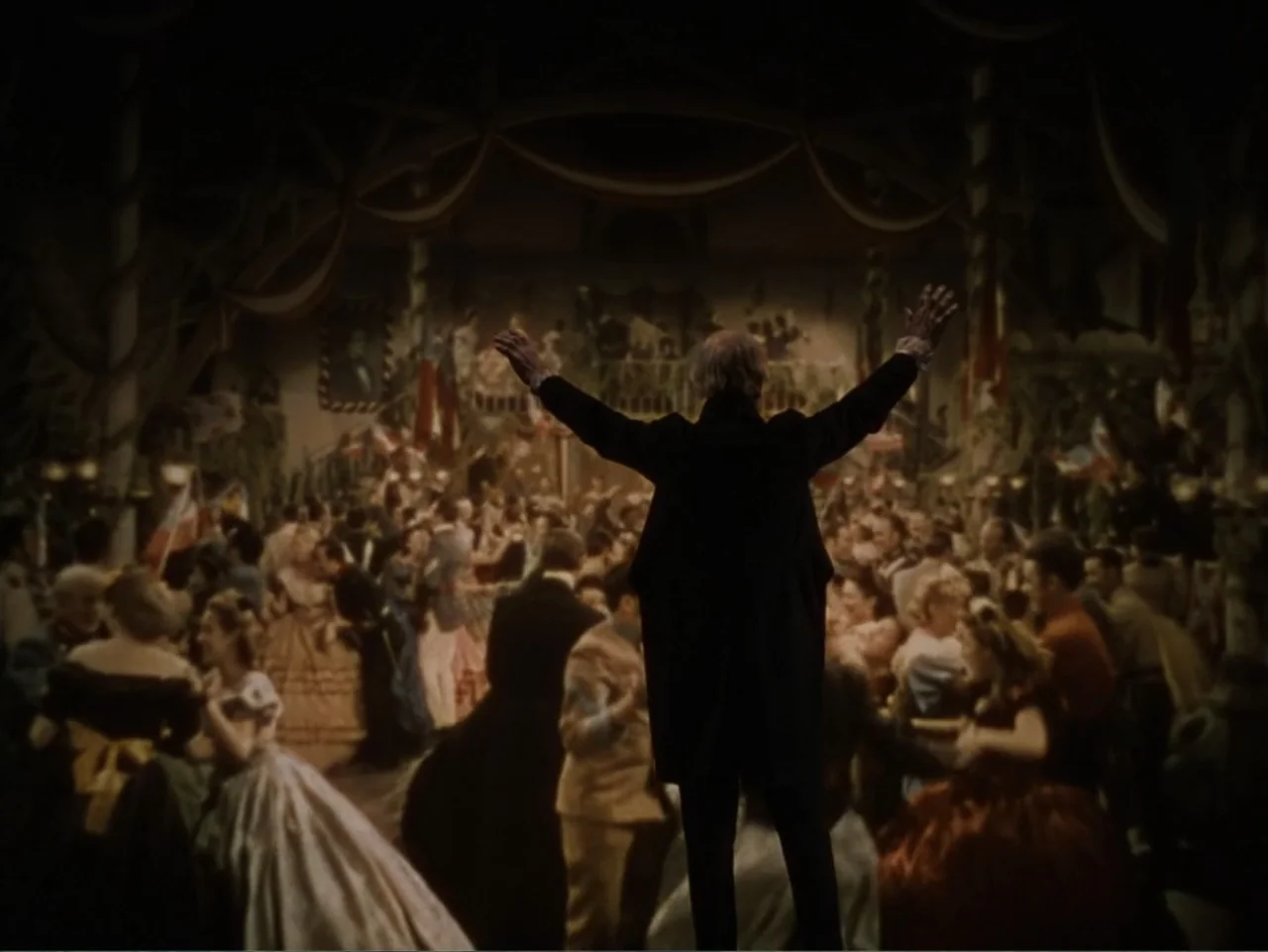 Gone with the Wind (1939) movie still: fullbody — A crowded 19th-century ballroom features festive decorations and people dancing in period attire.…