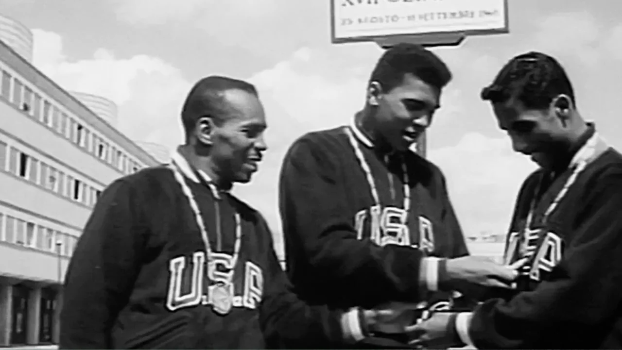 Ali & Cavett: The Tale of the Tapes (2018) movie still: medium — A group of athletes stands in front of a building during a bright day. Three men…