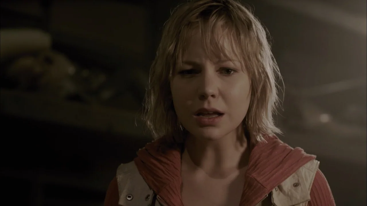 Silent Hill: Revelation 3D (2012) movie still: medium — A woman stands in a dimly lit interior with soft shadows cast behind her. She wears a tan…