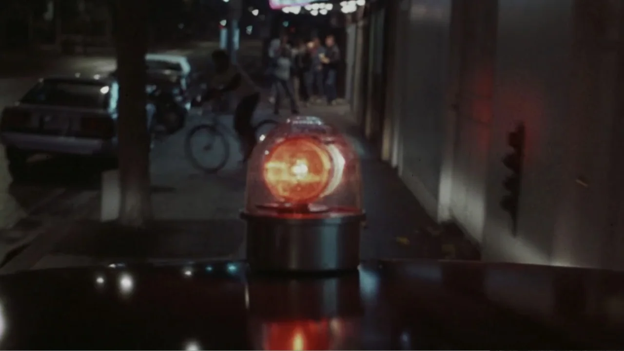 The Naked Gun: From the Files of Police Squad! (1988) movie still: closeup — A dark city street at night is visible in the blurry background behind…