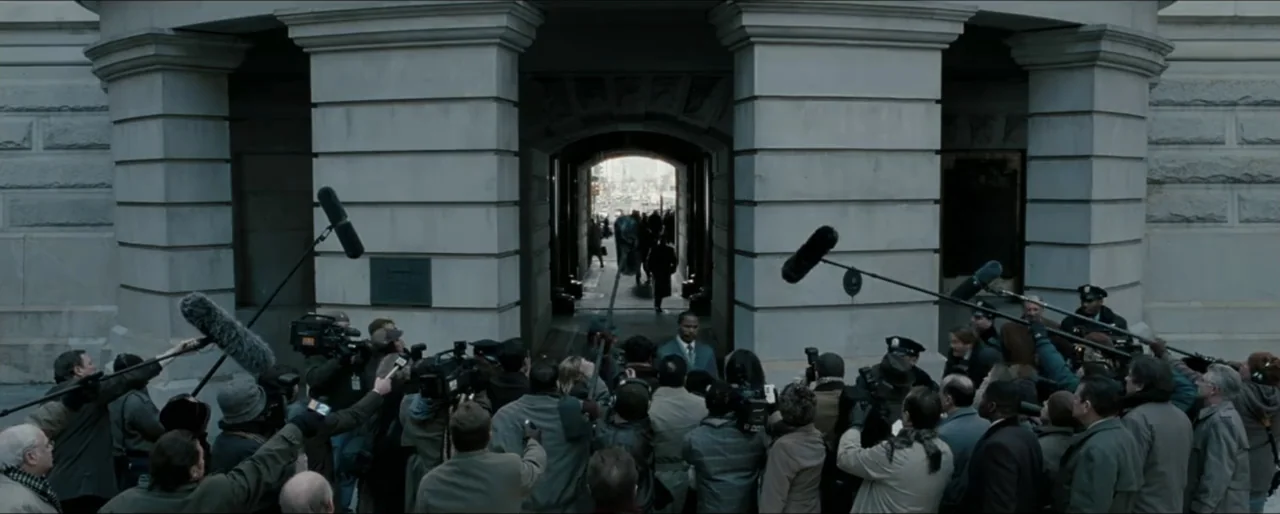 Law Abiding Citizen (2009) movie still: wide — A stone building entrance features large columns and an arched doorway leading to a bright exit. A…