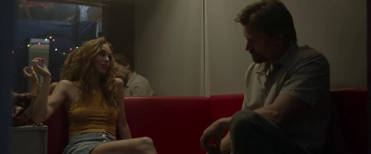 Small Crimes (2017) movie still: medium — A cramped interior with a bright red bench and a large reflective surface.