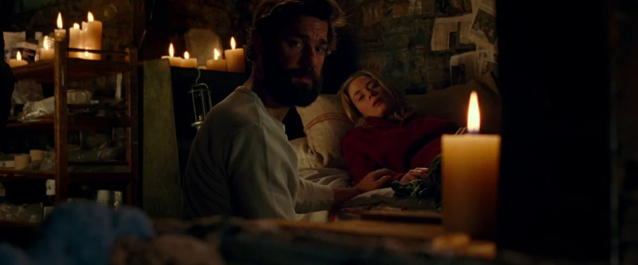 A Quiet Place (2018) movie still: medium — A dark, cramped cellar features stone walls cluttered with newspaper clippings and wooden storage…