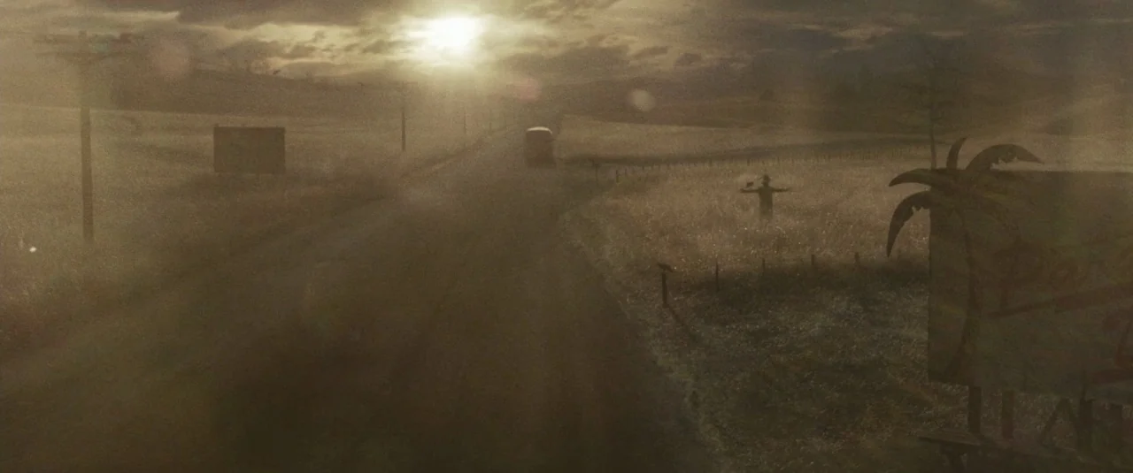 Sucker Punch (2011) movie still: establishing — A dusty rural highway stretches into the distance beneath a hazy golden sun. A stationary scarecrow…