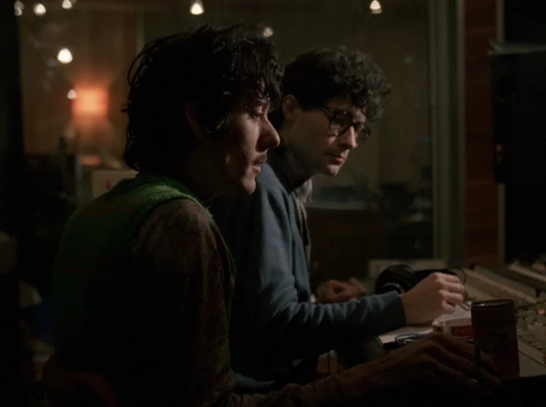 Keep Your Right Up (1987) movie still: medium — Two men sit at a professional audio mixing console in a dark, sound-dampened room. The man on the…