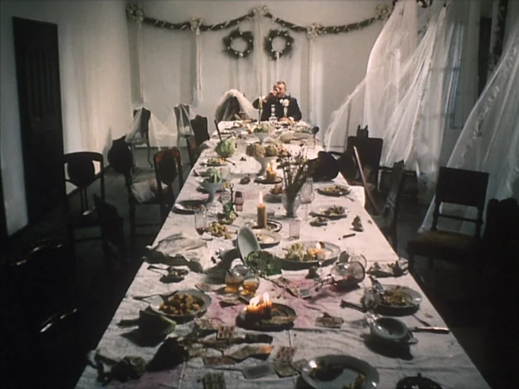 Valerie & Her Week of Wonders (1970) movie still: wide — A long dinner table is covered in white fabric with scattered food and debris. A single man…