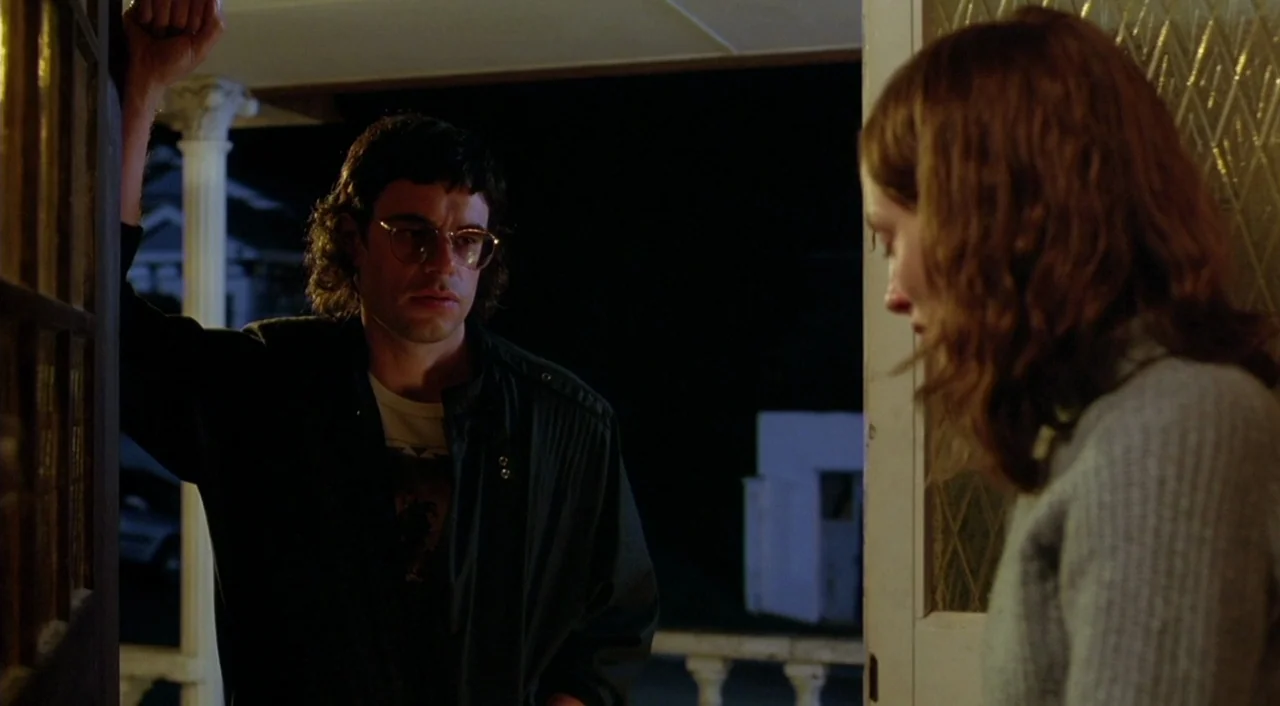Eagle Vs. Shark movie still: medium — A dark night on a wooden porch outside a house with a lit entrance. A man and a woman stand facing each other…