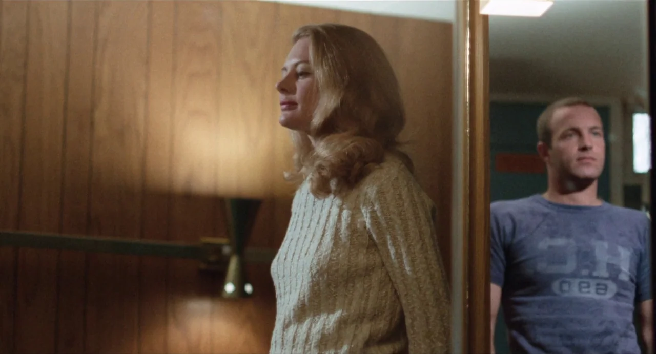 The Rain People (1969) movie still: medium — A room features wood paneled walls and a mounted mid-century modern light fixture. A woman stands in…