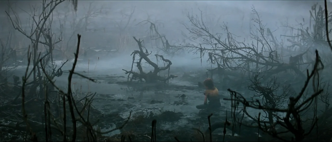 The NeverEnding Story (1984) movie still: wide — A dense, fog-filled swamp features dark, muddy water and gnarled, leafless trees. A young child…