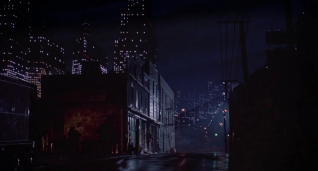Hellraiser III: Hell on Earth movie still: establishing — An empty urban street at night with dark buildings lining both sides of road. Tall…