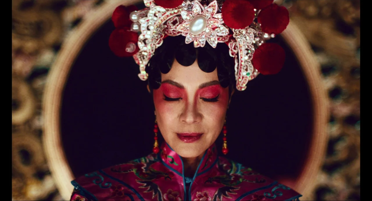 Everything Everywhere All At Once (2022) movie still: closeup — A close-up of a woman wearing elaborate traditional Peking opera headgear and…