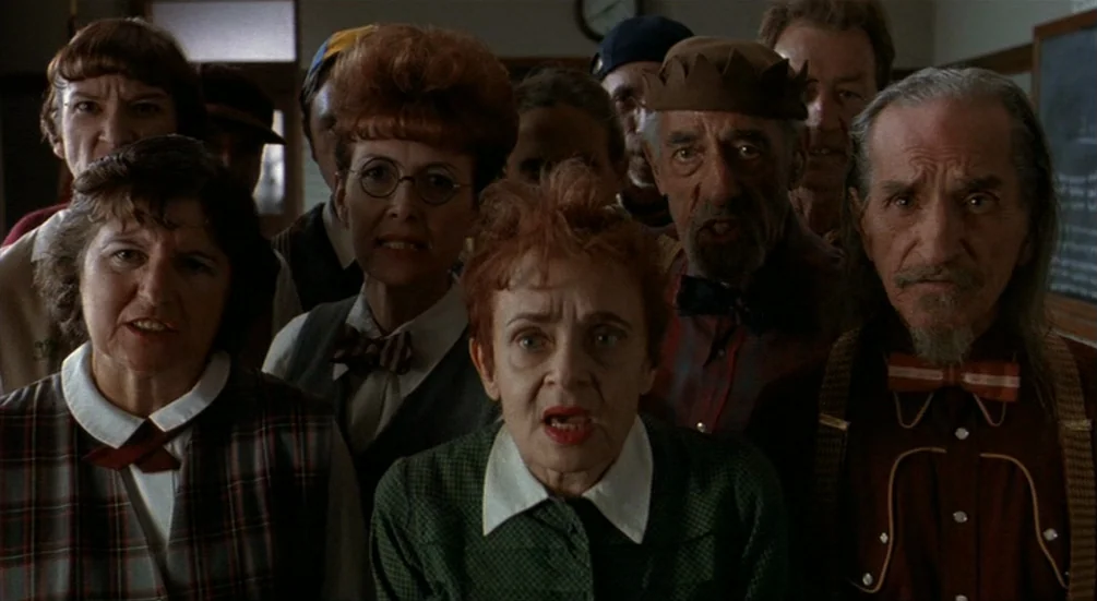 Freddy’s Dead: The Final Nightmare (1991) movie still: medium — A group of older individuals stand crowded together inside a dim institutional…