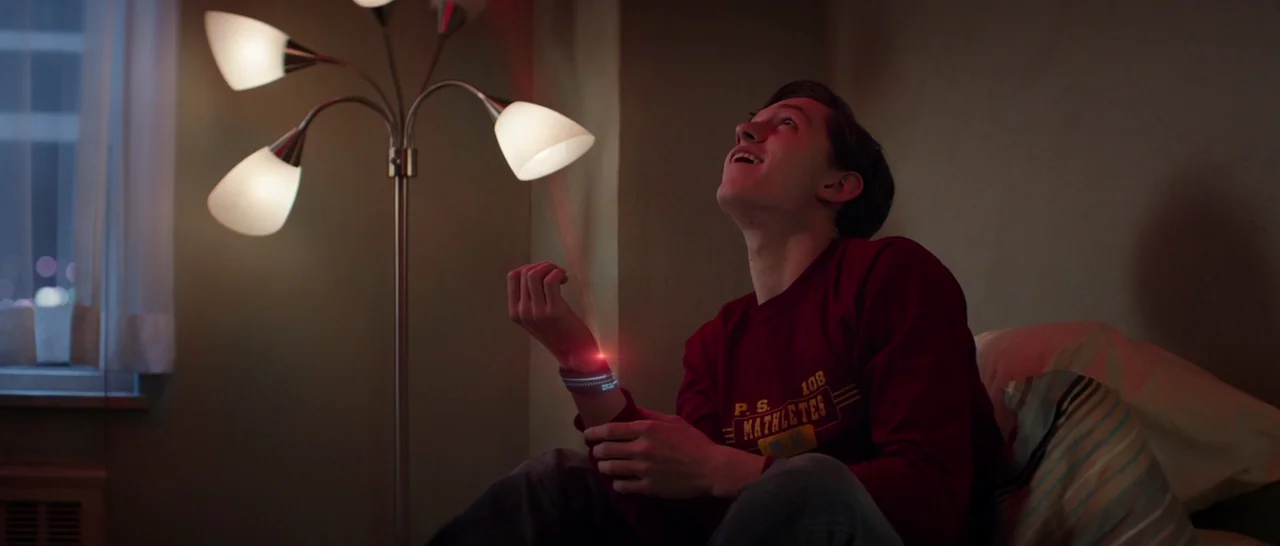 Captain America: Civil War (2016) movie still: medium — A dimly lit room features a multi-head floor lamp standing beside a bed. A teenager looks…