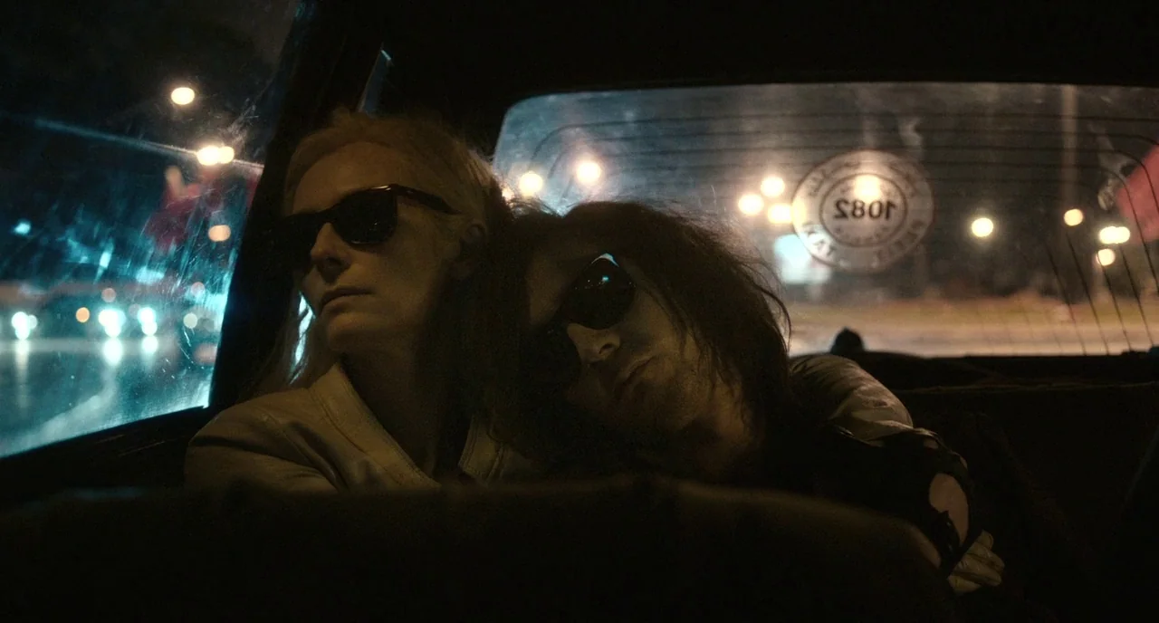 Only Lovers Left Alive (2013) movie still: medium — A dark night interior of a taxi cab showing the back window and seat. Two pale figures in…
