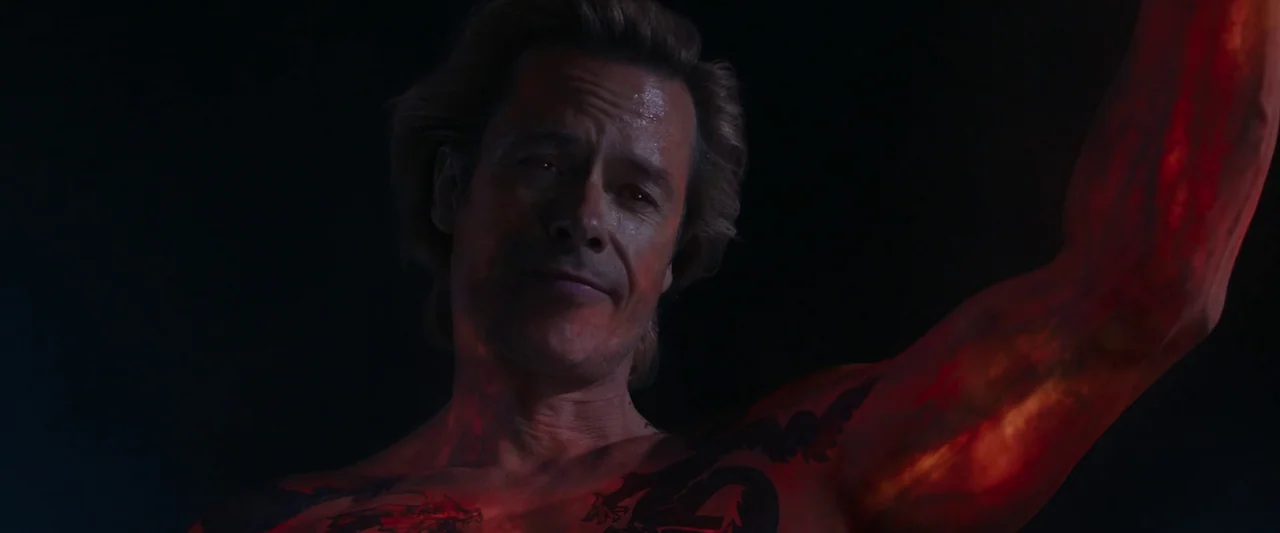 Iron Man 3 (2013) movie still: medium — A man stands in a dark environment with red light emanating from his body. He is shirtless and displays…