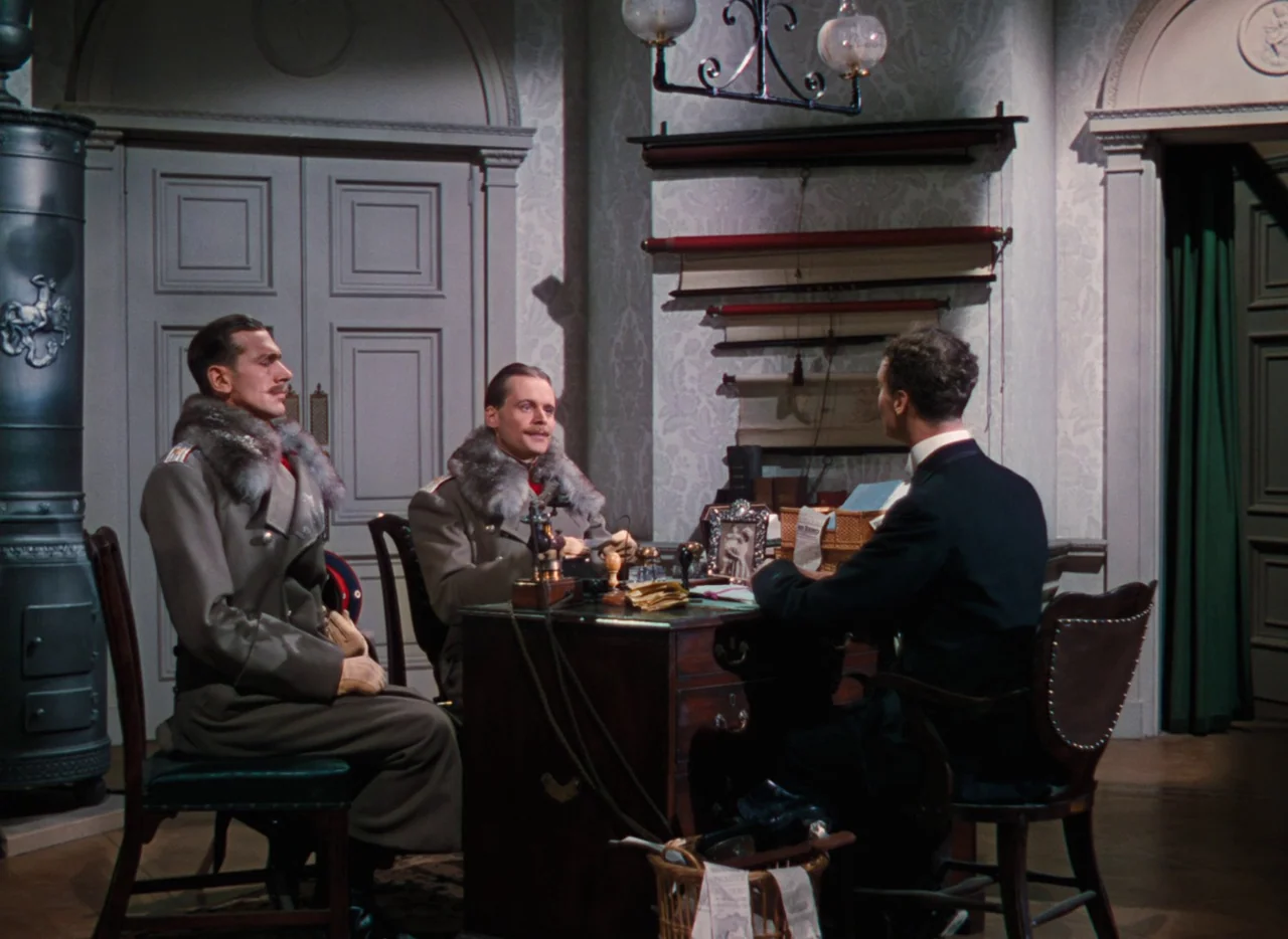 The Life and Death of Colonel Blimp (1943) movie still: medium — A formal office space features light patterned wallpaper and a large dark wood…