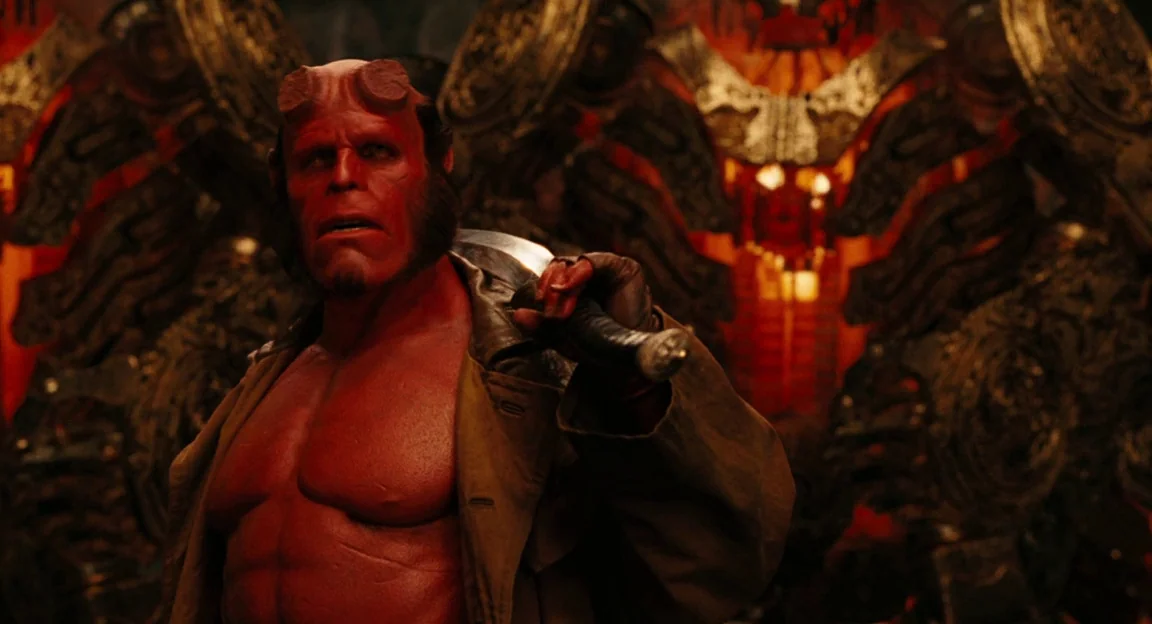Hellboy II: The Golden Army (2008) movie still: medium — An ornate, dimly lit chamber features massive metallic structures with intricate, glowing…