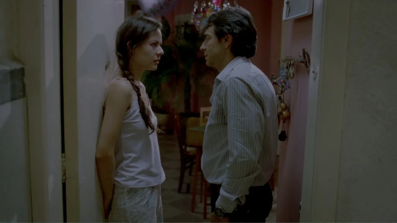 George Lopez: It's Not Me, It's You (2012) movie still: medium — A dimly lit residential hallway connects to an adjacent room with pink walls. A…
