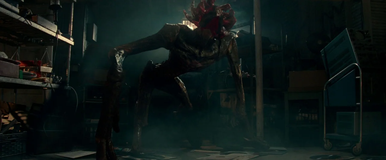 A Quiet Place (2018) movie still: fullbody — A cluttered basement filled with shelving units and industrial electrical equipment on rolling carts. A…