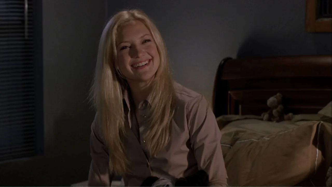 How to Lose a Guy in 10 Days (2003) movie still: medium — A dimly lit bedroom features a bed with a wooden headboard and blinds. A young woman with…