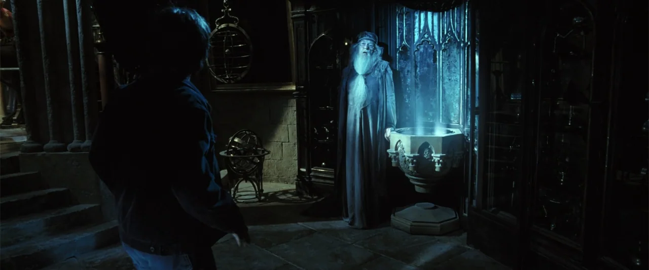Harry Potter and the Goblet of Fire (2005) movie still: medium — An interior stone chamber features ornate woodwork and a glowing basin emitting…