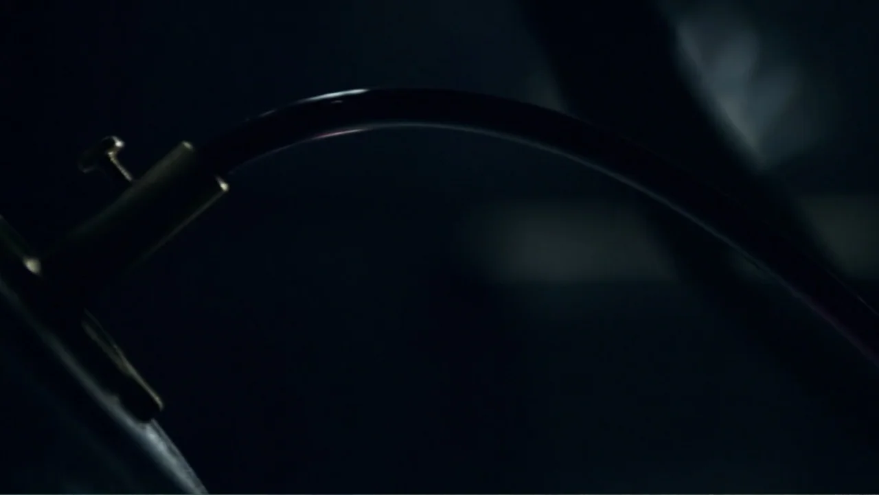 Underworld: Blood Wars (2016) movie still: closeup — A dark, out-of-focus interior setting contains a curved metal conduit. The metal pipe is…