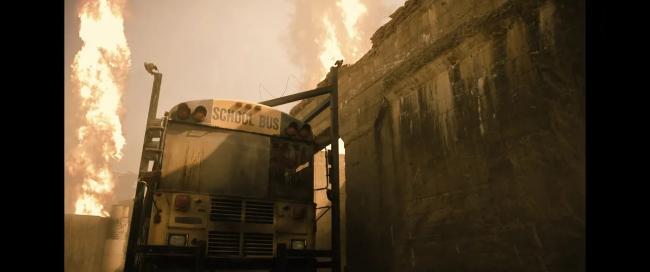 Batman v Superman: Dawn of Justice (2016) movie still: wide — A yellow school bus is positioned beside a massive, weathered concrete defensive…