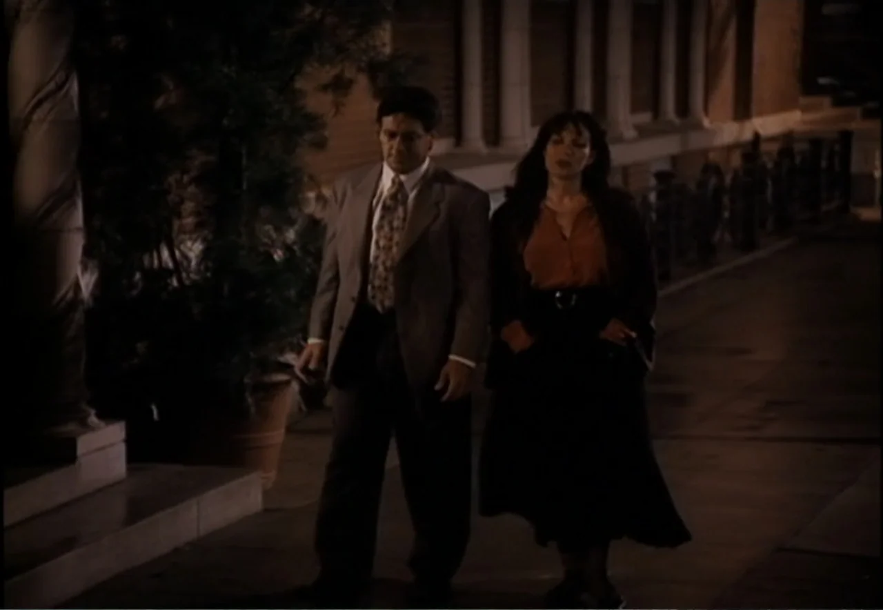 Chance of a Lifetime (1998) movie still: fullbody — A nighttime exterior scene shows a man and a woman walking along a sidewalk. The building facade…