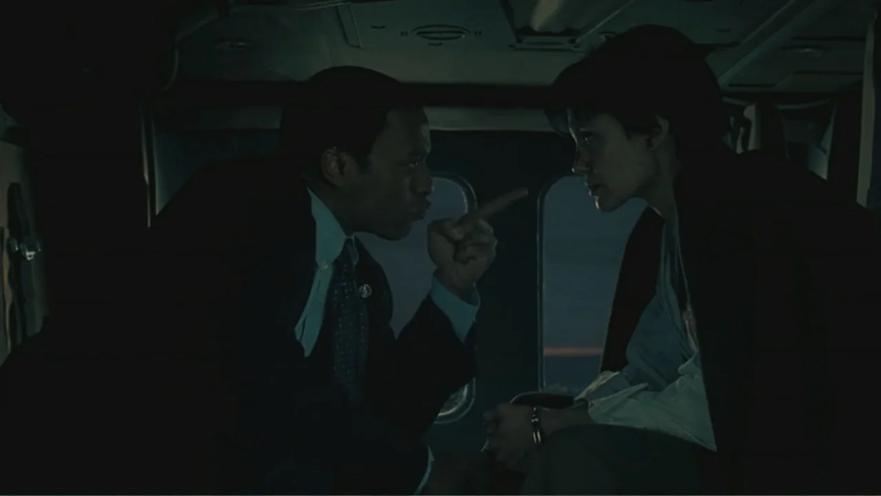 Salt (2010) movie still: medium — A dark, cramped vehicle interior features two individuals facing one another in close proximity. A man leans…
