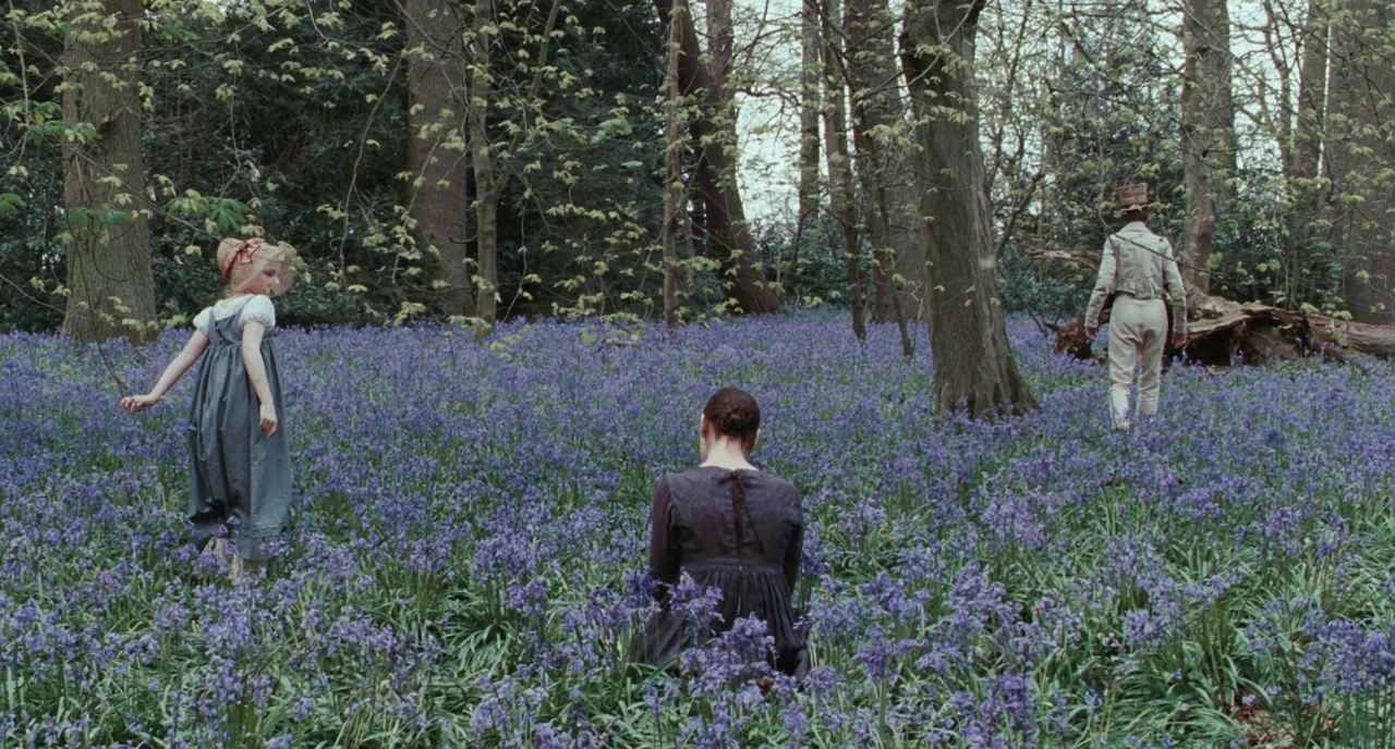 Bright Star (2009) movie still: wide — A dense woodland floor is completely covered in a carpet of blooming bluebells. Three people are positioned…