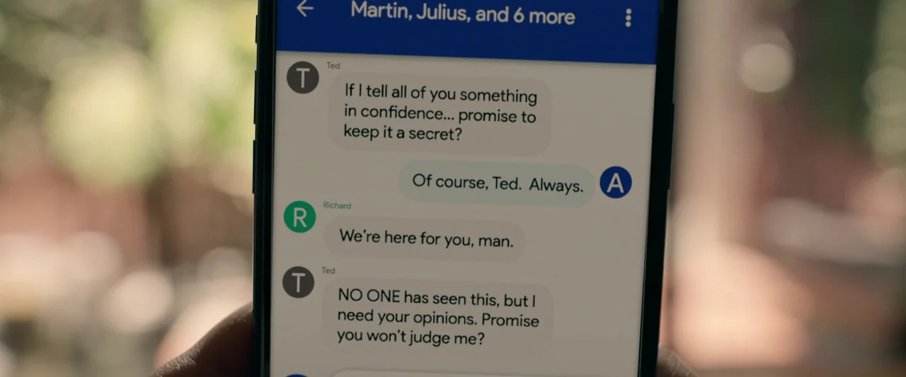 The Hunt (2020) movie still: closeup — A close-up view of a smartphone screen showing a group text message thread. The messages involve Ted asking…