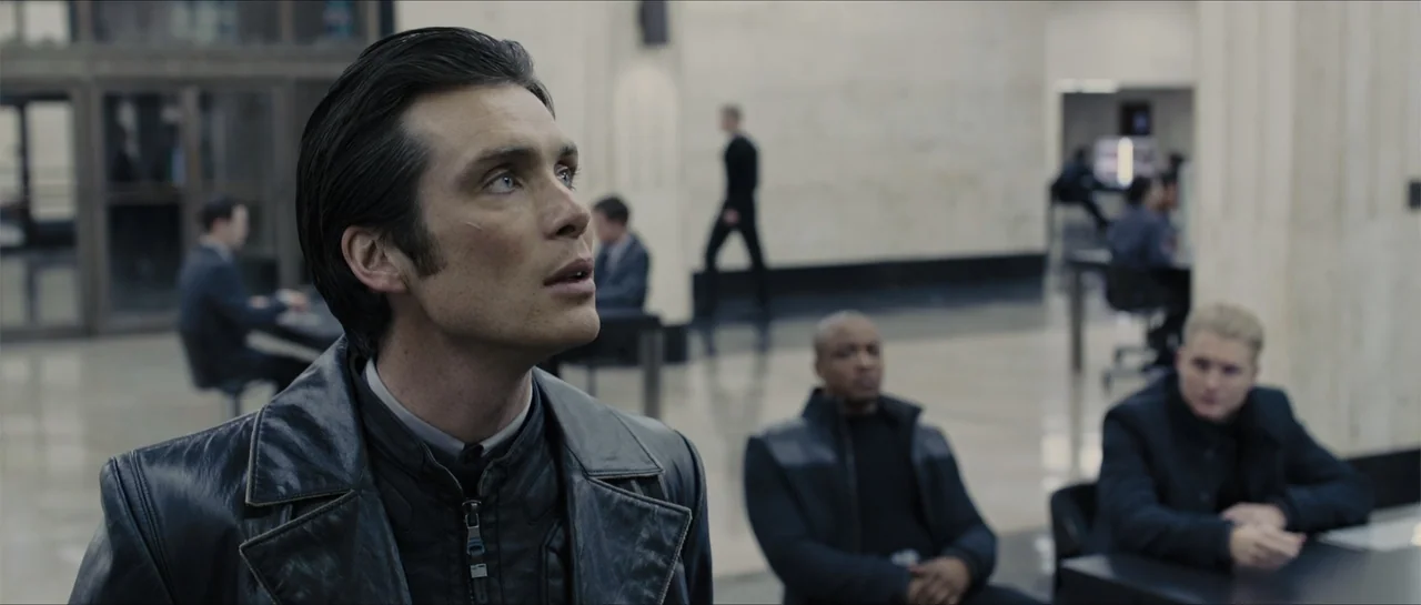 In Time (2011) movie still: medium — A spacious, modern interior with polished floors and minimalist architectural lines. A man in a leather jacket…