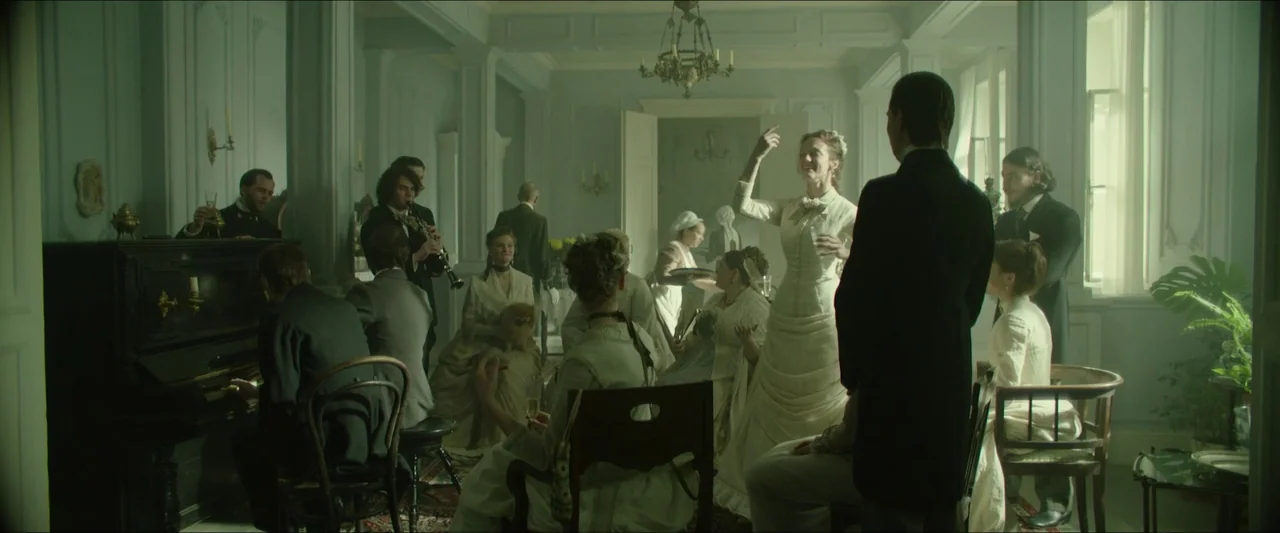 Tchaikovsky’s Wife (2022) movie still: wide — An elegant nineteenth-century interior features high ceilings, ornate moldings, and a period…