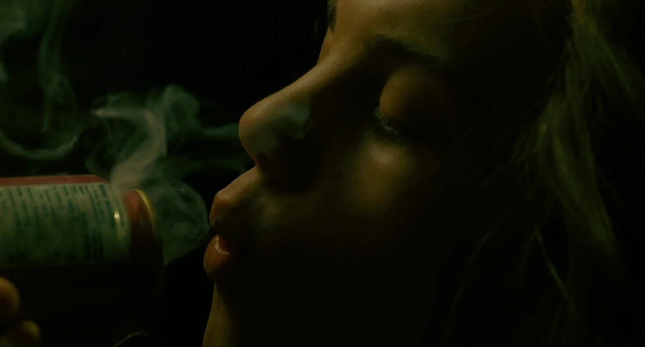 It’s Only The End Of The World (2016) movie still: closeup — A dark, dimly lit room is illuminated by a narrow light source. A woman in profile…