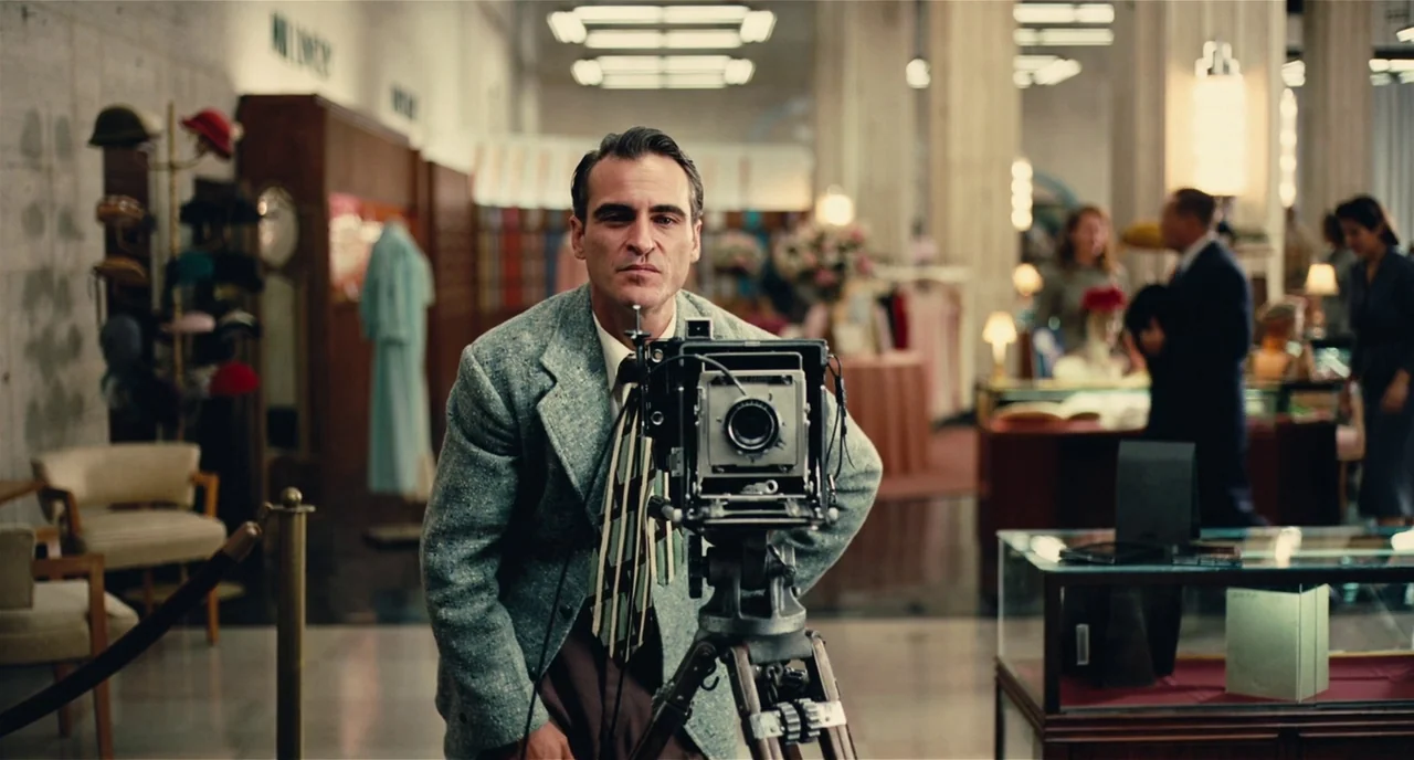 The Master (2012) movie still: medium — A spacious retail department store with glass display cases and clothing racks visible behind. A middle-aged…