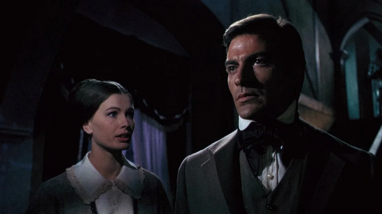 The Whip and The Body (1963) movie still: medium — A dimly lit room in a Victorian manor with dark architectural shadows in background. A man in a…