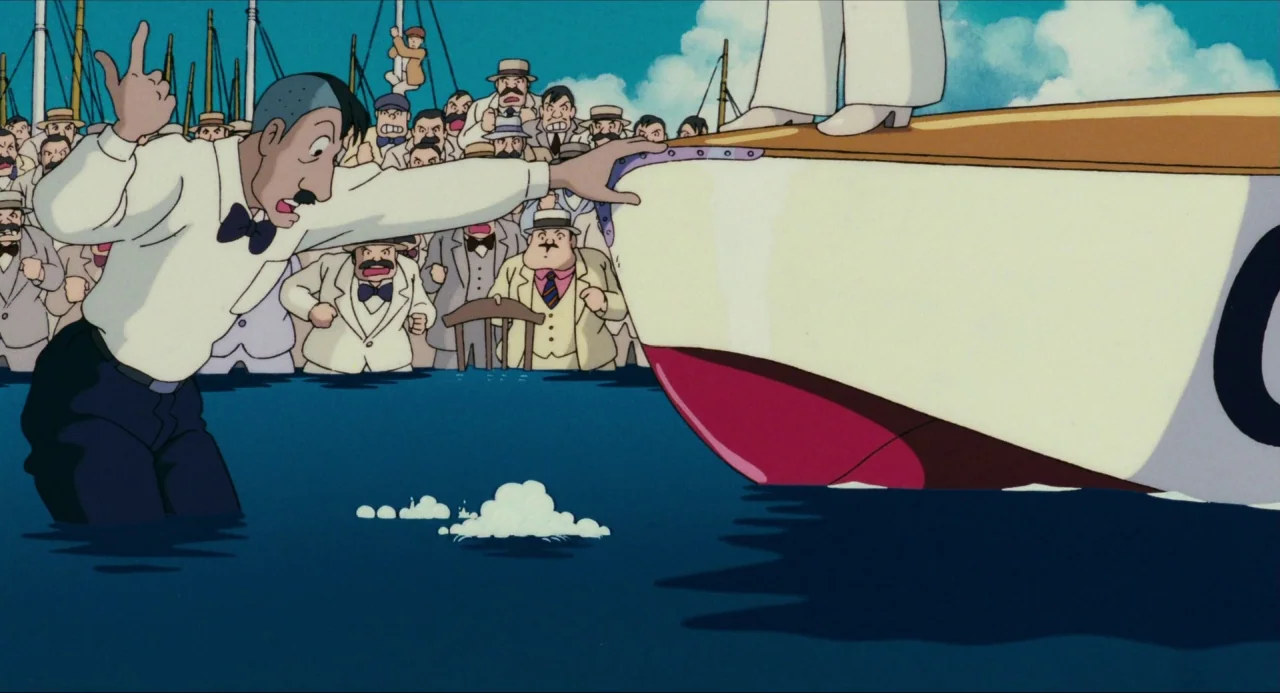 Porco Rosso (1992) movie still: medium — A harbor scene where a man stands in water next to a large boat. Behind him a crowd of men in suits watches…